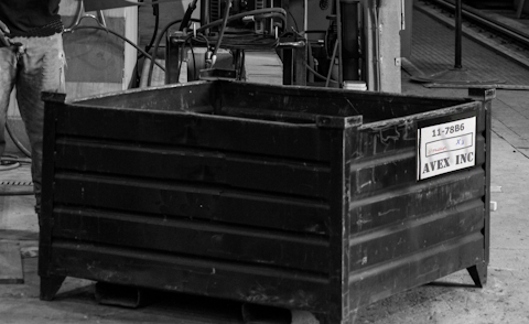 Black and white photo of a metal bin. 